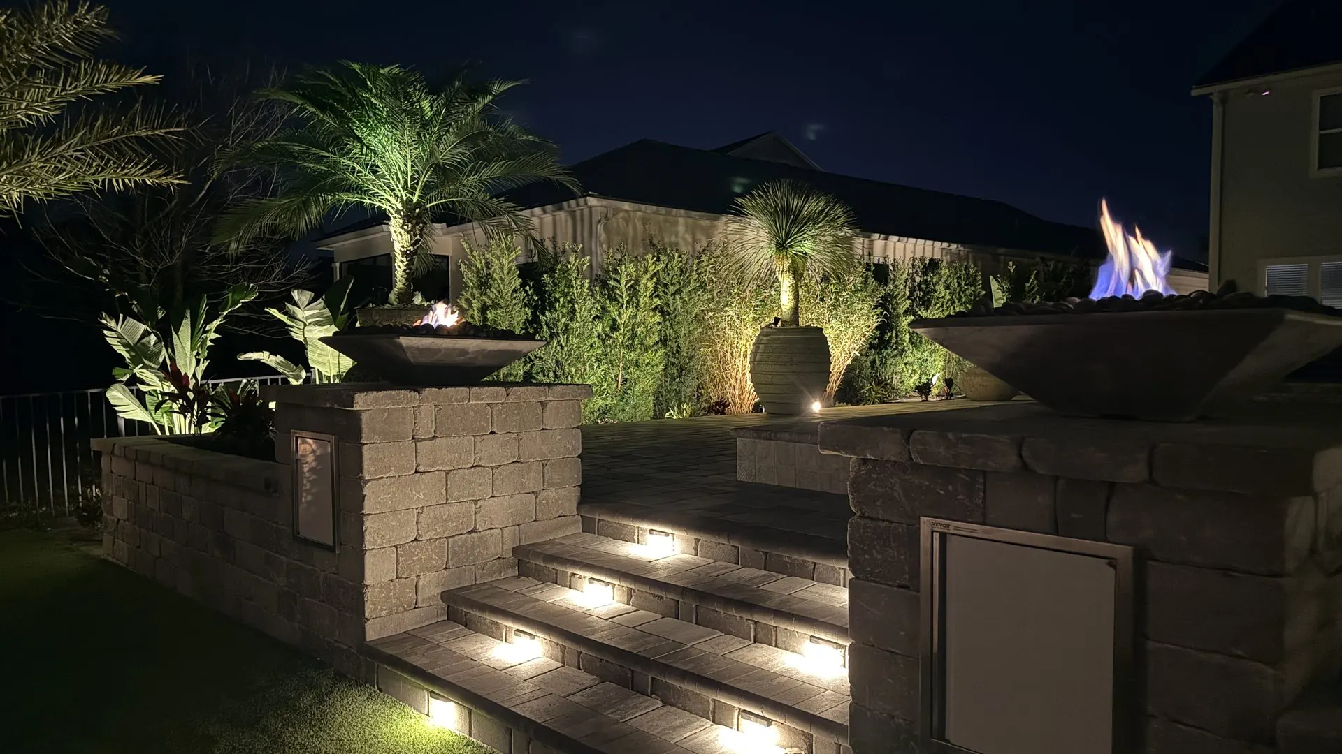 Custom paver patio with lit steps, seating walls and fire bowls in St. Augustine, Florida